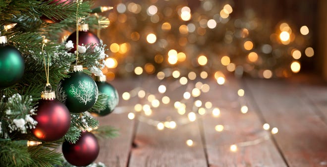 A Christmas tree next to some blurry lights