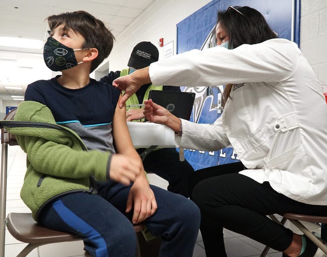 Without a flinch Evan Abbott, 9, gets a COVID-19 vaccination from Oakland County Health Department nurse Deb Collins during a Nov. 22 clinic at Lakeland High School in White Lake, Michigan.