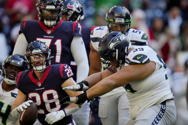 Seattle Seahawks defensive tackle Al Woods (99) celebrates after stopping Houston Texans running back Rex Burkhead (28) on a run during the first half of an NFL football game, Sunday, Dec. 12, 2021, in Houston. (AP Photo/Eric Christian Smith)