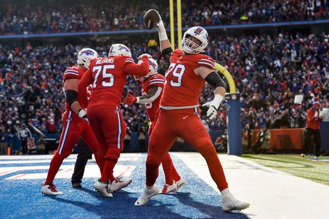 Buffalo Bills offensive tackle Spencer Brown (79) celebrates after running back Devin Singletary (26) scores a touchdown in the first half of an NFL football game against the Carolina Panthers, Sunday, Dec. 19, 2021, in Orchard Park, N.Y. (AP Photo/Adrian Kraus )