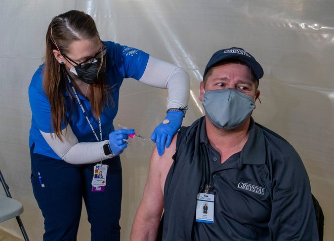 Nurse Bethany Morrill gives Jim Godfrey of Grafton, Mass., his COVID-19 booster  vaccination shot at Mercantile Center in Worcester, Mass., on Nov. 23.