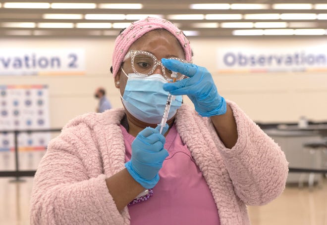 Virtua nurse Stephanie Vieux of Burlington Township, N.J., prepares a shot of the Pfizer  vaccine at the Burlington County COVID-19 Vaccine Mega-Site in Mount Laurel, N.J., on Dec. 9.
