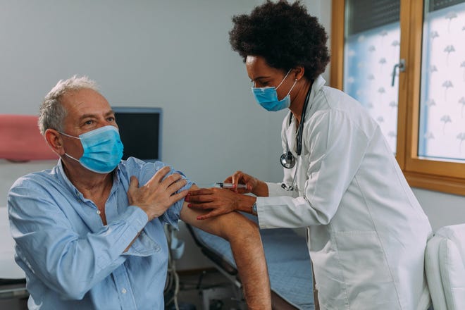 A healthcare professional administers a shot. Health officials in southwestern Utah said this week they believe the omicron wave of COVID-19 may have reached its peak after pushing case counts, hospitalizations and reported deaths to their highest numbers of the pandemic in January.