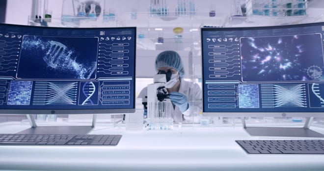 Un scientifique examine des modèles d'ADN dans un laboratoire de recherche génétique moderne.  Regarder à travers la verrerie de laboratoire.