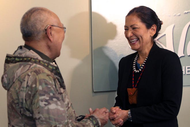 U.S. Interior Secretary Deb Haaland, right, laughs with Nelson Angapak Sr. on Thursday in Anchorage, Alaska, during Haaland’s visit to the state.