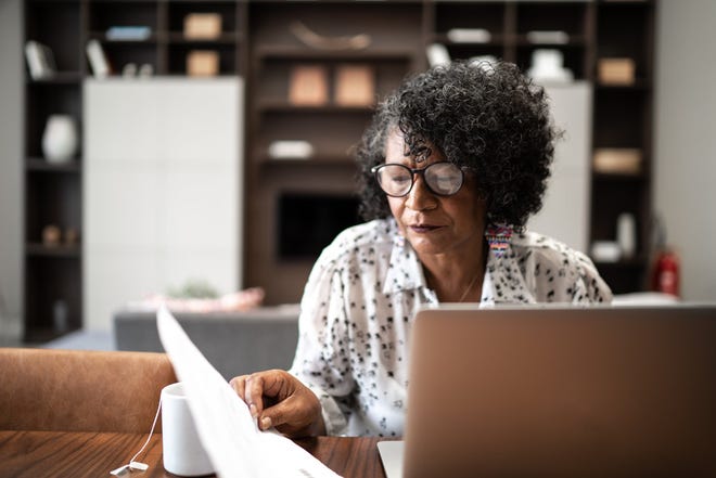 Older adult looking at financial paperwork.