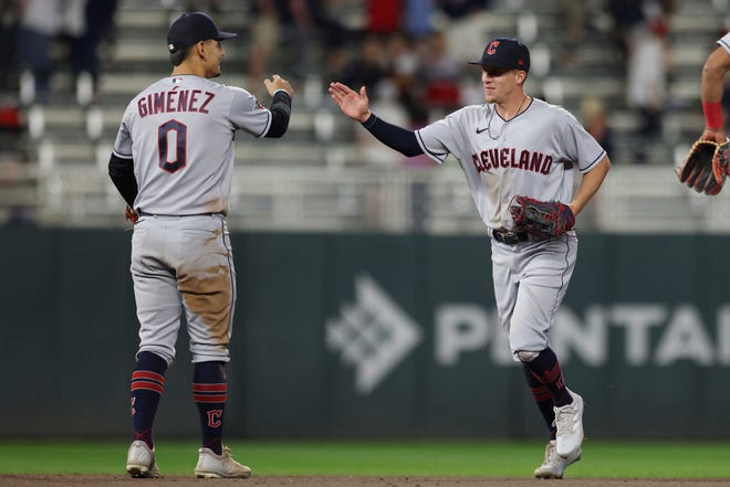 Cleveland Guardians' Andres Gimenez (0) high-fives Myles Straw, right, after defeating the Minnesota Twins during the 10th inning of a baseball game Saturday, May 14, 2022, in Minneapolis. (AP Photo/Stacy Bengs)
