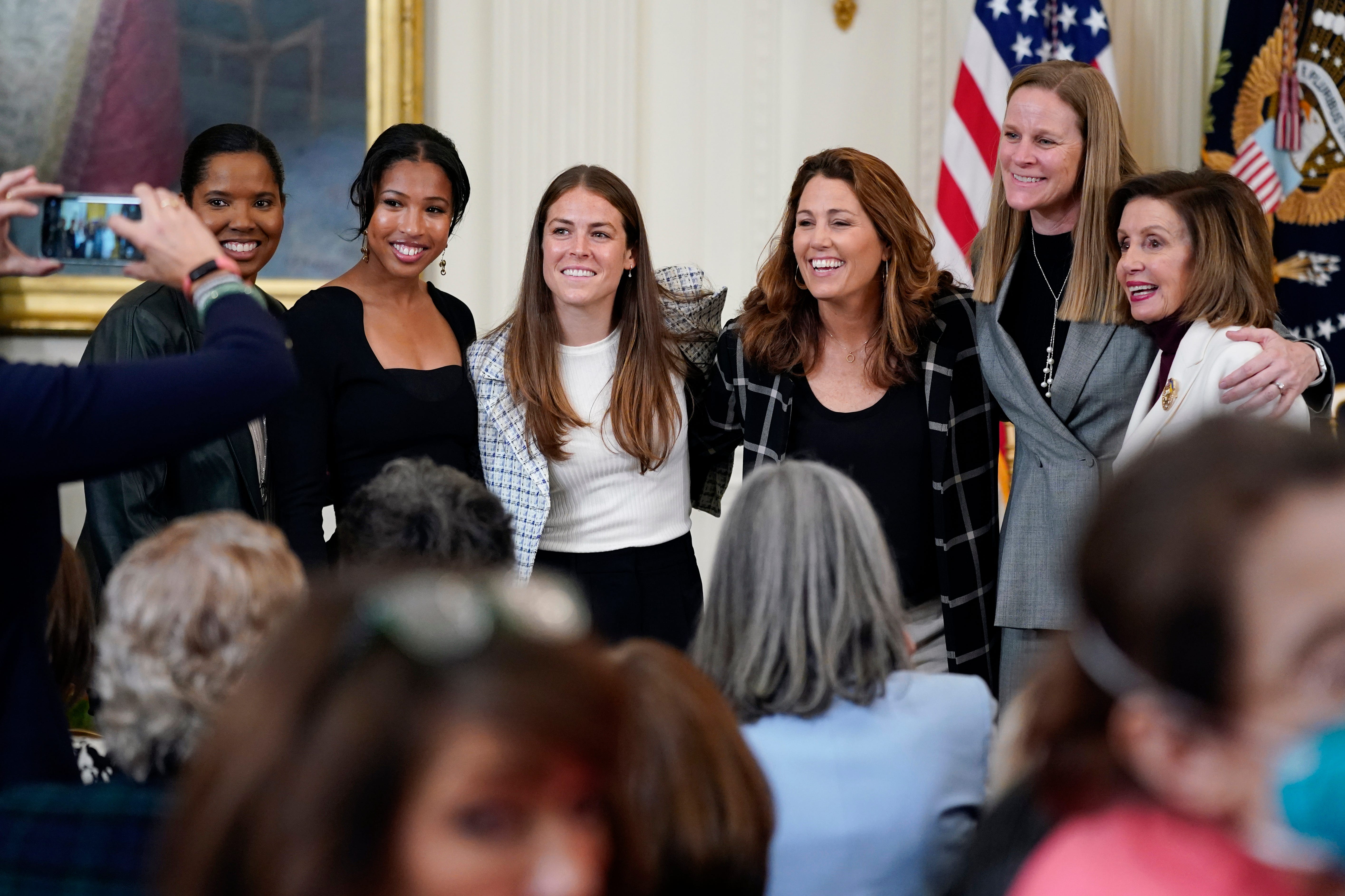 Former members and members of the U.S. Women's National soccer team, from left,  Briana Scurry, Margaret 'Midge' Purce, Kelley O'Hara, Julie Foudy, and Cindy Parlow Cone, president of U.S. Soccer, pose for a photo with House Speaker Nancy Pelosi of Calif., before an event to celebrate Equal Pay Day and Women's History Month on March 15, 2022, at the White House.