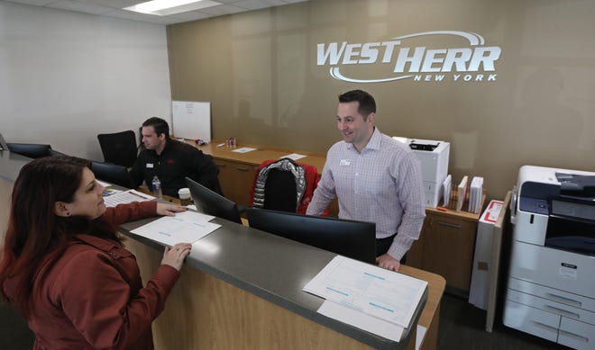 Jay Jay Vanderstyne, general manager, right, goes over paperwork with Jessica Tosto, a sales consultant at West Herr Toyota of Rochester.