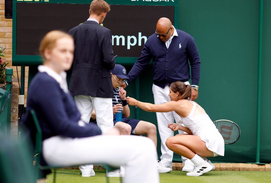 Jodie Burrage gives a ball boy some refreshments after during her first-round match against Lesia Tsurenko at Wimbledon.