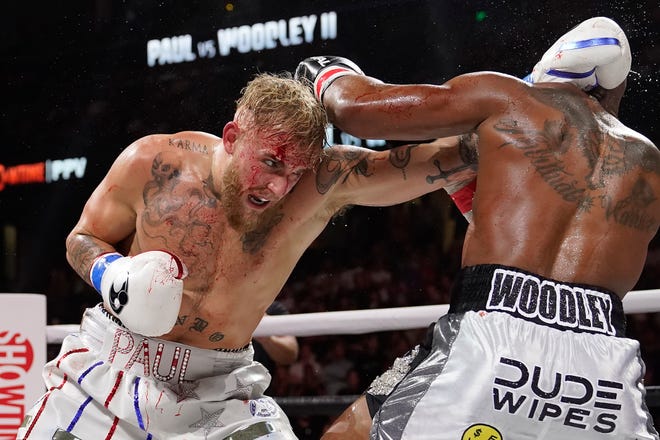 Jake Paul, left, hits Tyron Woodley with a punch during the third round of a cruiserweight boxing bout Dec. 18, 2021, in Tampa, Fla. Paul continues to plot his course in boxing, next facing Anderson Silva.