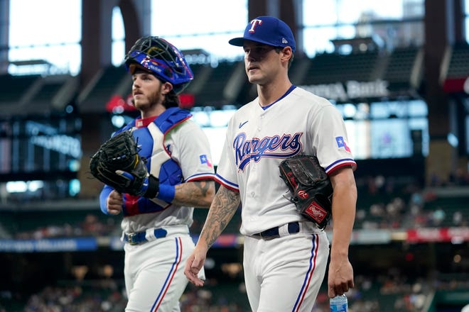 Texas Rangers catcher Jonah Heim and pitcher Cole Ragans walk to the dugout from the bullpen before the team's baseball game against the Chicago White Sox, Thursday, Aug. 4, 2022, in Arlington, Texas. Ragans made his debut in the majors. (AP Photo/Tony Gutierrez)