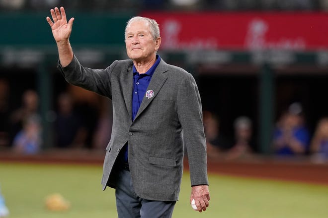 Former President George W. Bush waves as he takes the field to participate in the ceremonial first pitch to recognize the 21st anniversary of Patriot Day on Sept. 11, 2022 before a baseball game between the Toronto Blue Jays and the Texas Rangers in Arlington, Texas. (AP Photo/LM Otero)