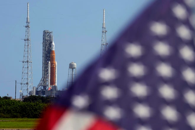 An American flag flutters as NASA's New Moon rocket sits on Launch Pad 39-B, and its liftoff at the Kennedy Space Center earlier this month in Cape Canaveral, Florida, was called off.