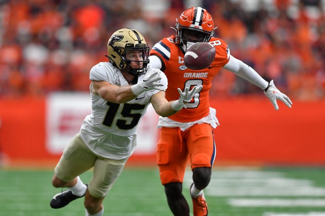 Purdue wide receiver Charlie Jones, left, reaches for a pass as Syracuse defensive back Garrett Williams defends during the first half of an NCAA college football game in Syracuse, N.Y., Saturday, Sept. 17, 2022. (AP Photo/Adrian Kraus)