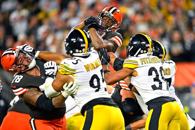 Cleveland Browns running back Nick Chubb, top, leaps into the end zone for a touchdown during the second half of the team's NFL football game against the Pittsburgh Steelers in Cleveland, Thursday, Sept. 22, 2022. (AP Photo/David Richard)