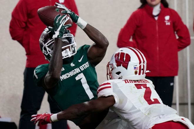 Michigan State wide receiver Jayden Reed (1), defended by Wisconsin cornerback Ricardo Hallman (2), catches the game winning touchdown in overtiime of an NCAA college football game, Saturday, Oct. 15, 2022, in East Lansing, Mich. (AP Photo/Carlos Osorio)