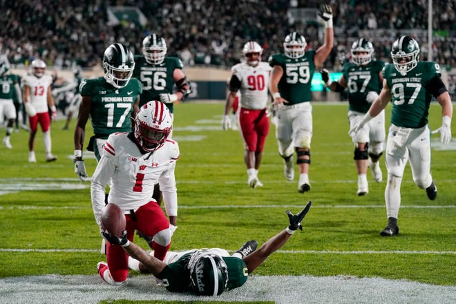 Michigan State wide receiver Keon Coleman (0), who was defended by Wisconsin cornerback Jay Shaw (1) reacts after a touchdown in overtime during an NCAA college football game, Saturday, Oct. 15, 2022, in East Lansing, Mich. (AP Photo/Carlos Osorio)