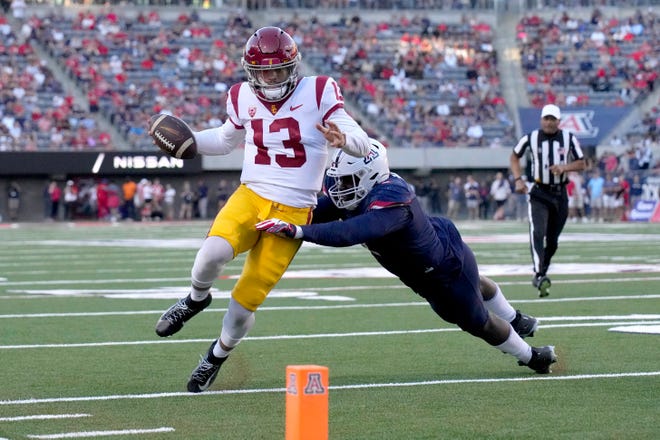 Zuid-Californië quarterback Caleb Williams (13) probeert de verdedigingslijnwachter Jalen Harris van Arizona aan te pakken tijdens de eerste helft, zaterdag 29 oktober 2022, in Tucson, Arizona.