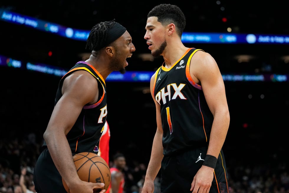 Phoenix Suns guard Devin Booker (1) celebrates his basket with forward Josh Okogie during the second half of an NBA basketball game against the New Orleans Pelicans, Saturday, Dec. 17, 2022, in Phoenix. (AP Photo/Matt York)
