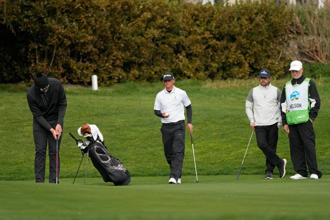 Beau Hossler (left) putts on the 13th green on Friday at Pebble Beach with fellow Tour pro Max McGreevy (center) and country singer Lukas Nelson (second from the right) after returning to the golf course following the collapse of an amateur caddie for their other playing partner, Geoff Couch.
