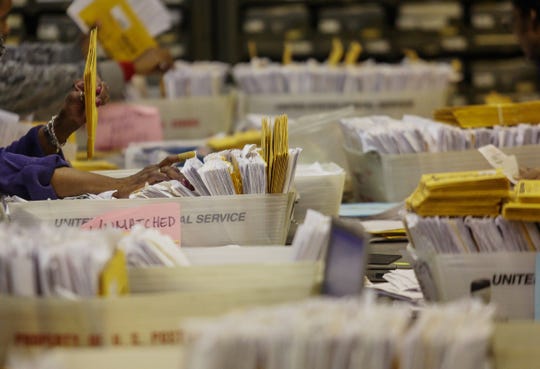 Workers at the City of Detroit Department of Elections in Detroit sort through absentee ballots. The November general election will likely see a record number of absentee ballots cast in Michigan, but voter advocacy groups have argued that state restrictions on transporting voters to the polls creates a barrier to in-person voting.
