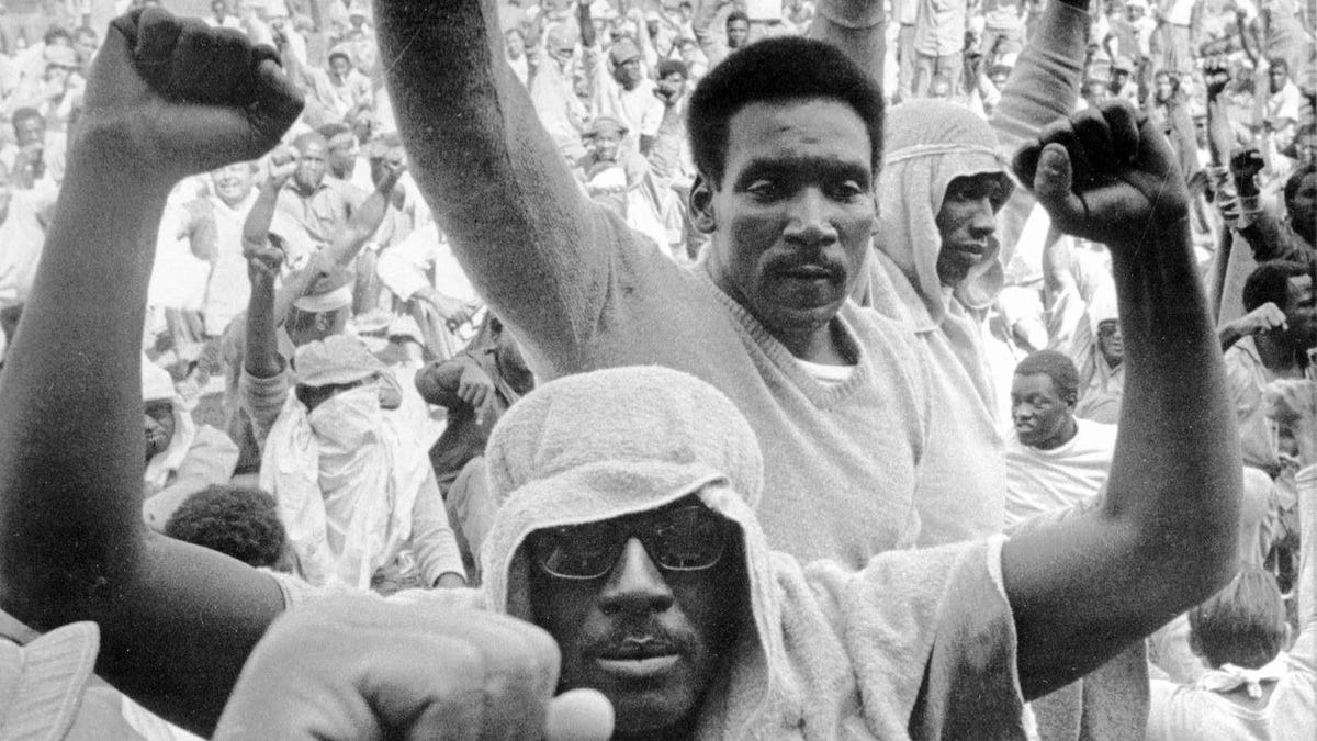 Inmates of Attica state prison raise their fists during a negotiation session with state prisons Commissioner Russell Oswald on Sept. 10, 1971.