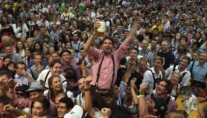 A man shows a beer mug after the opening of Oktoberfest on Saturday in Munich, Germany.