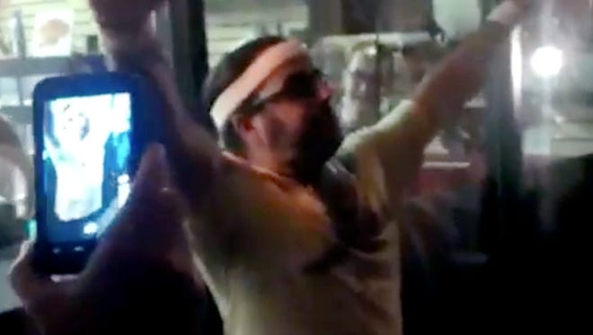 In this file frame grab made from video provided by Sarah Bernard, Edward Archbold celebrates winning a roach-eating contest.