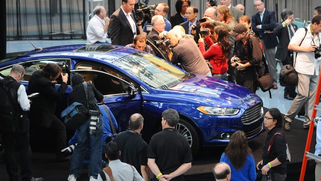 Photographers swarm around the Ford Fusion after it was named Green Car Journal's 2013 Green Car of the Year at the Los Angeles Auto Show.