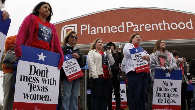 Local citizens and employees of the Planned Parenthood clinic in San Angelo, Texas gather in front of the clinic Thursday, March, 8, 2012 to participate in the "Don't Mess with Texas Women" rally.