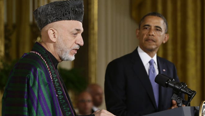 President Obama listens as Afghan President Hamid Karzai speaks during a news conference at the White House on Friday.