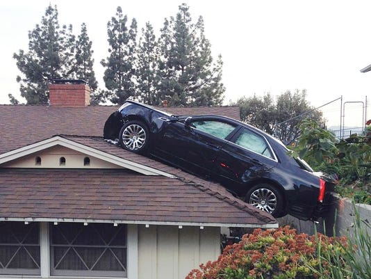 Man's car lands on neighbor's roof in strange accident