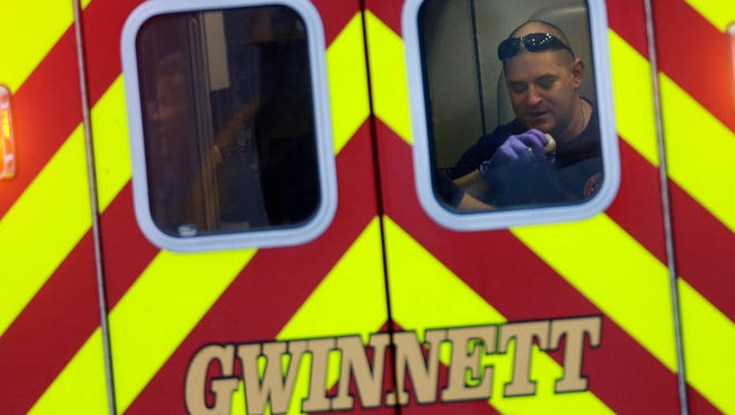 An EMT works in the back of an ambulance as it leaves an Suwanee, Ga., subdivision after an explosion and gunshots were heard near the scene where a man was holding four firefighters hostage Wednesday.