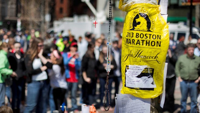 Visitors pause at a makeshift memorial in Copley Square on Saturday for victims of the Boston Marathon bombings.