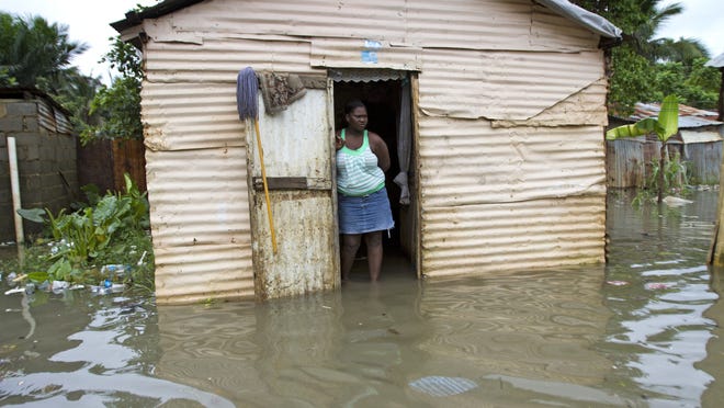 A woman observes from her flooded house in eastern Santo Domingo Thursday.