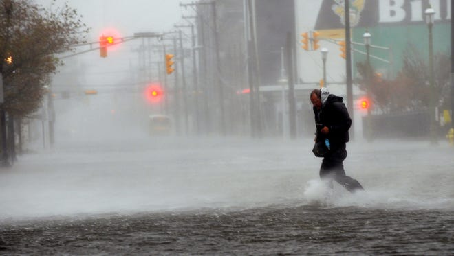 Michael Wirtz, of Wilmington, Del., braves flood waters and high winds that arrive with Hurricane Sandy along North Michigan Avenue in Atlantic City, N.J. on Monday.