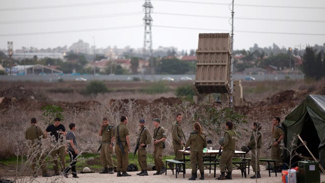 Israeli soldiers stand guard Saturday near the Iron Dome defense system launch site in Tel Aviv.