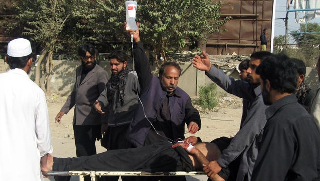 Pakistani Shiite Muslims carry an injured blast victim at a hospital following a bomb explosion in the city of Dera Ismail Khan on Sunday.