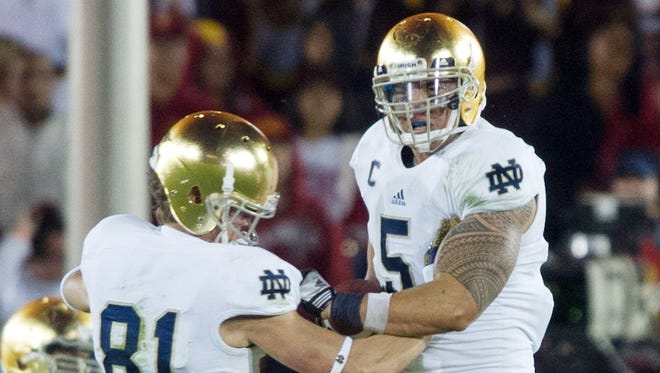 Notre Dame linebacker Manti Te'o (5) and wide receiver John Goodman (81) celebrate in the fourth quarter against USC at the Los Angeles Memorial Coliseum. Notre Dame won 22-13.