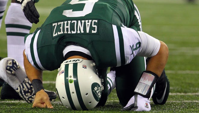 New York Jets quarterback Mark Sanchez gets up from the turf after being hit during the second half on Thanksgiving against the New England Patriots at Metlife Stadium. Patriots defeated the Jets 49-19.