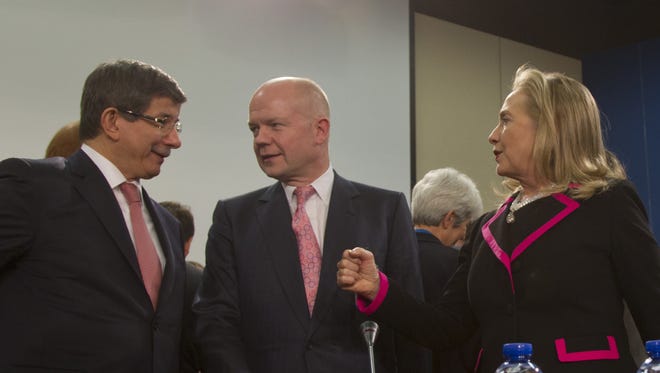 From left, Turkey's Foreign Minister Ahmet Davutoglu, British Foreign Minister William Hague and U.S. Secretary of State Hillary Clinton share a word during a meeting of NATO foreign ministers in Brussels today.