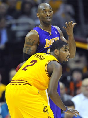Lakers guard Kobe Bryant shrugs while defended by Cavaliers guard Kyrie Irving during Tuesday's 100-94 loss.