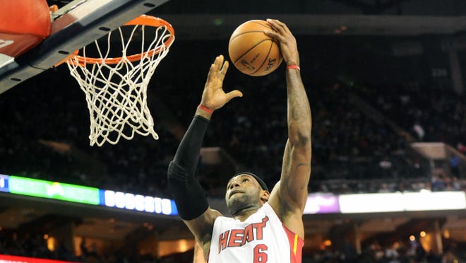 Miami Heat forward LeBron James (6) drives to the basket and scores during the game against the Charlotte Bobcats at Time Warner Cable Arena.