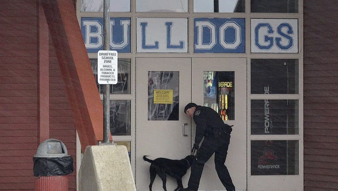 A police K-9 officer and his bomb sniffing partner do an exterior search of a high school in Grangeville, Idaho.