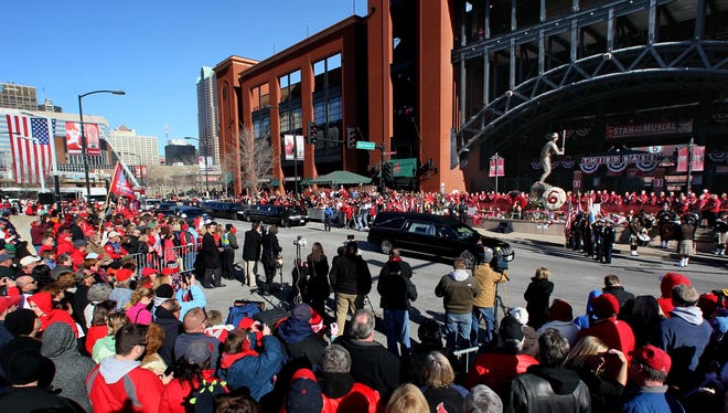 A hearse carrying Stan Musial's body stops in front of his statue outside Busch Stadium for a wreath-laying ceremony.