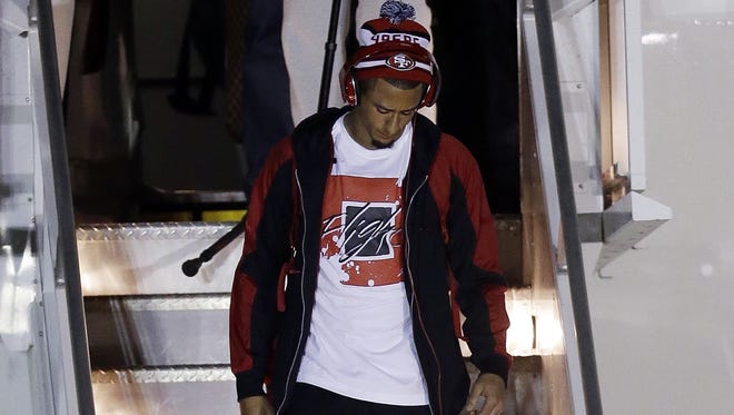 San Francisco 49ers quarterback Colin Kaepernick arrives with teammates Sunday night at the Louis Armstrong International Airport for Super Bowl XLVII.