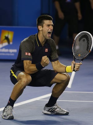 Novak Djokovic celebrates after clinching his third consecutive Australian Open crown with a 6-7 (2-7), 7-6 (7-3), 6-3, 6-2 victory against Andy Murray of Britain.