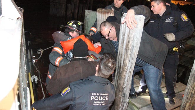 Yonkers, N.Y., police and emergency personnel pull one of two people safely out of the frigid Hudson River on Jan. 27, 2013, after their plane landed in the river.