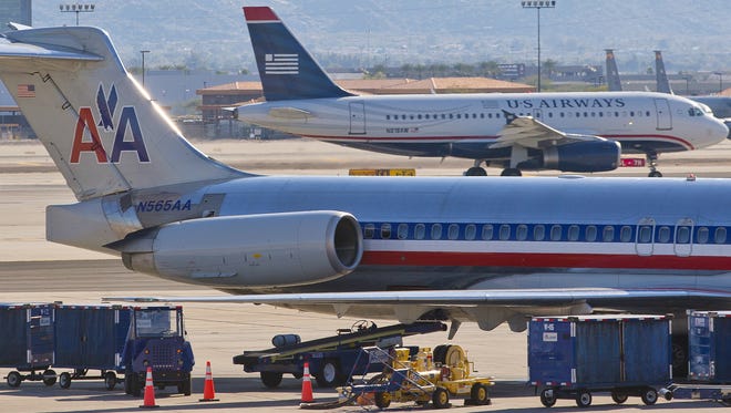 A US Airways plane lands behind an American Airlines plane at Phoenix Sky Harbor Airport on Feb. 13.